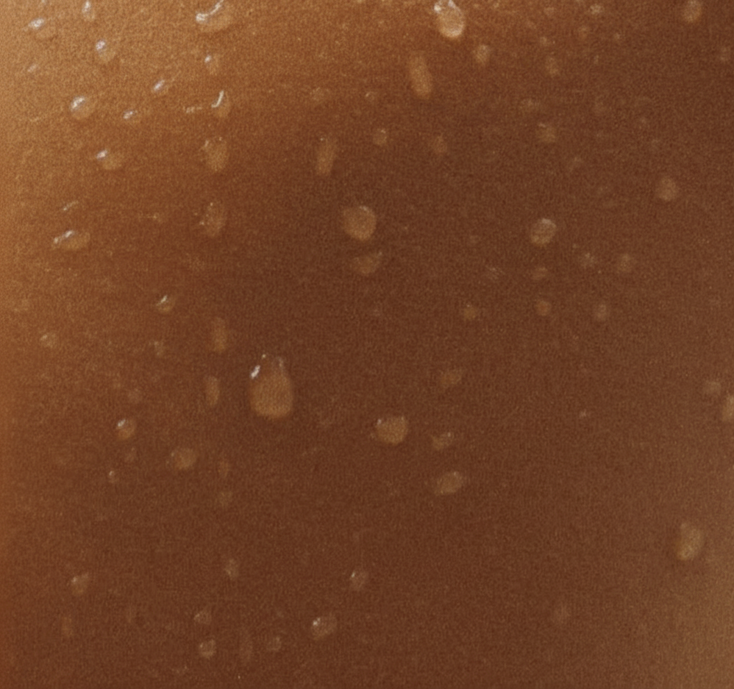Create a cleaned version of this same photograph with the words “dear body, i love you” completely removed from the image. Reconstruct the area naturally using the surrounding skin texture, water droplets, lighting, shadows, and color. Keep the composition and every other detail unchanged. Do not add any text, tint, veil, or overlay.